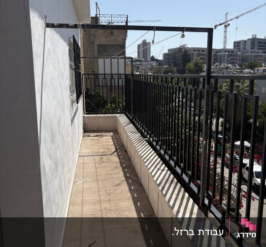 מעקה מתכת שחור במרפסת וסורג ישר בחלון